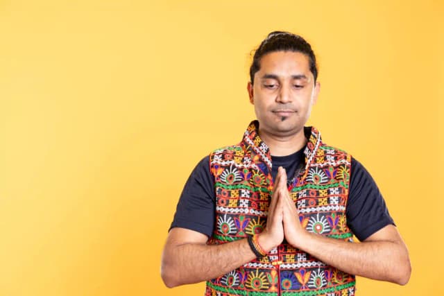 Close up of Patola silk fabric showing natural dye colours in traditional double ikat patterns with rich red, mustard, and green tones.